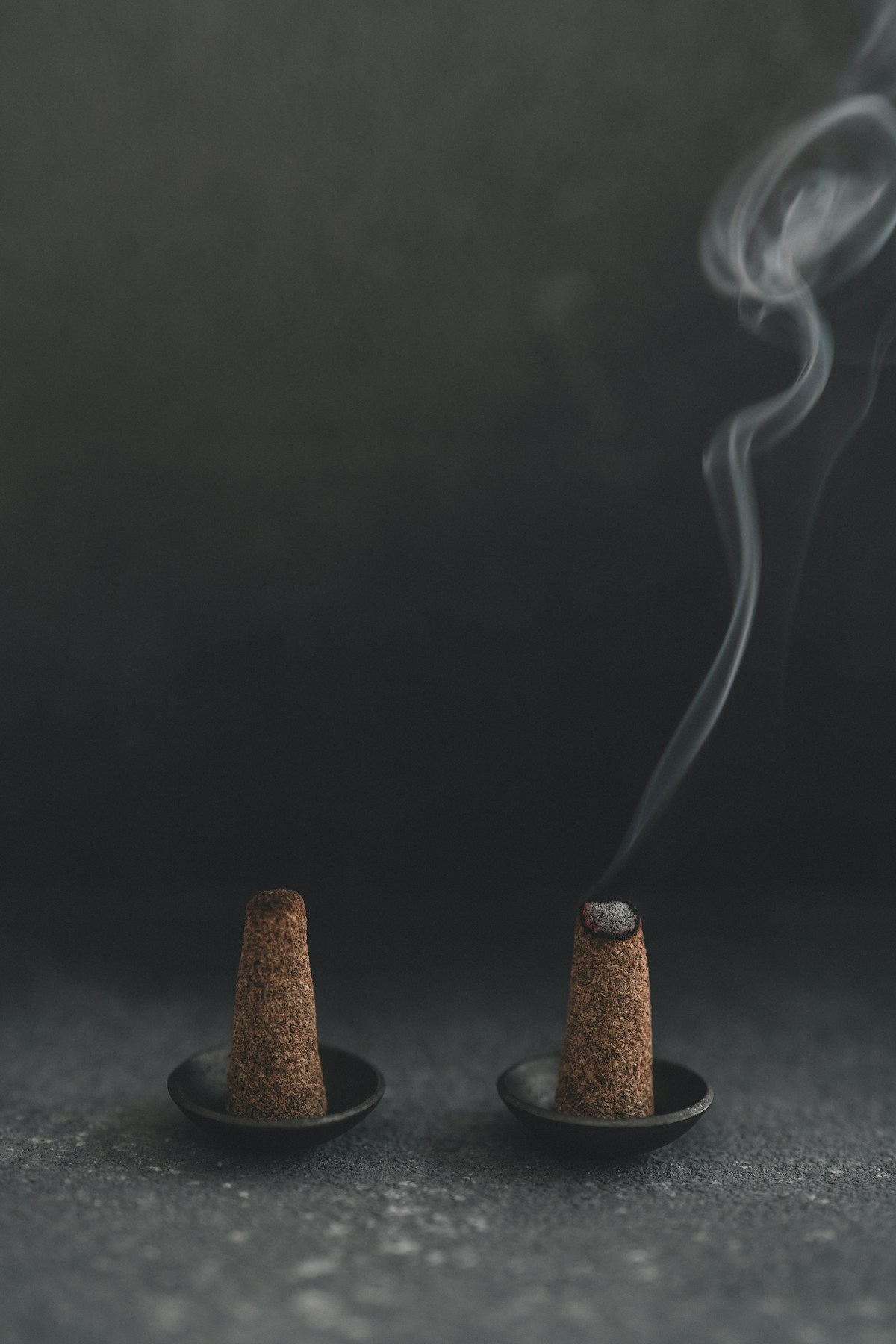 Incense cones smoldering on a dark backdrop
